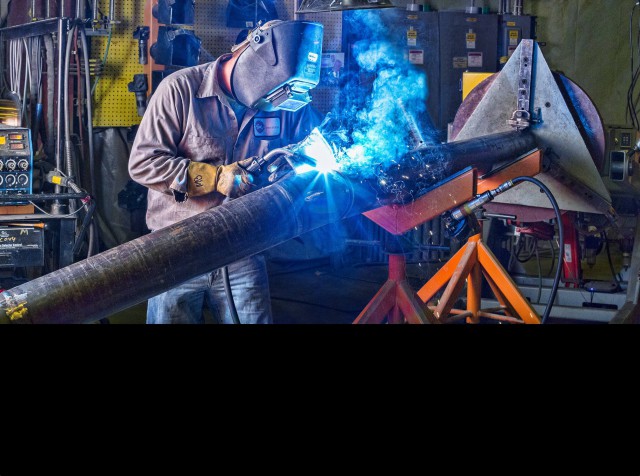 Team Industry welder using a welding positioner to fabricate a pipe spool.